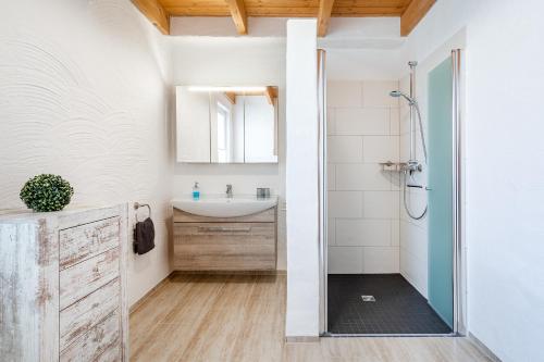 een badkamer met een wastafel en een douche bij Nr 13 Robbe in Aurich