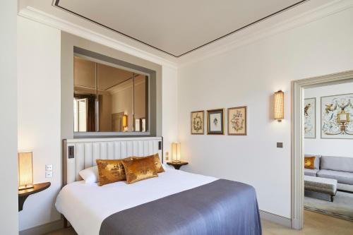 a bedroom with a large bed and a mirror at Hotel de Montesquieu in Paris
