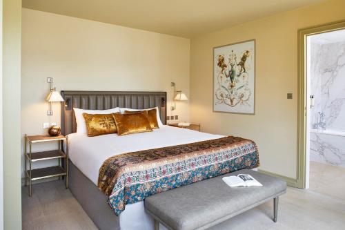 1 dormitorio con 1 cama grande y un banco junto a él en Hotel de Montesquieu en París