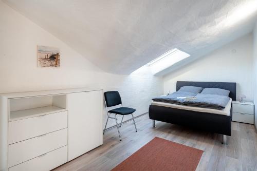 een slaapkamer met een bed, een bureau en een stoel bij Nr 17 Seestern in Aurich