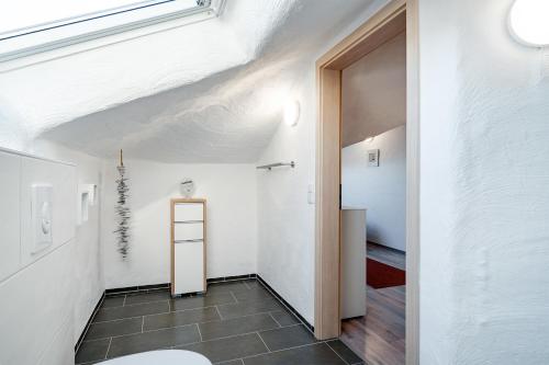 een badkamer met een witte muur en een toilet bij Nr 17 Seestern in Aurich
