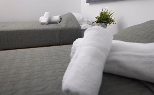 1 dormitorio con cama con sábanas blancas y sofá en Lovely 2 Bed Apartment in Larnaca City Centre, en Lárnaca