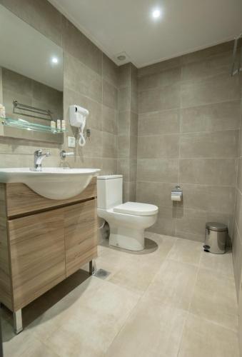 a bathroom with a sink and a toilet at Palatino Hotel in Lixouri