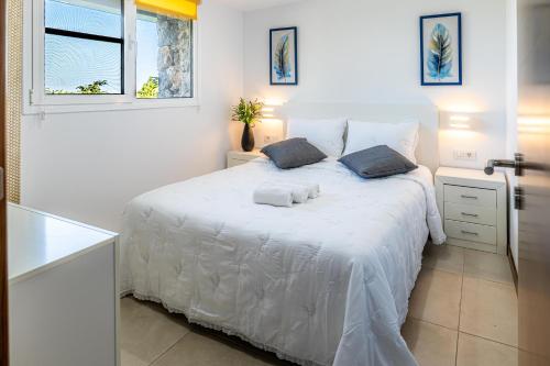 um quarto branco com uma cama branca e 2 almofadas em Estancia Julieta em La Orotava
