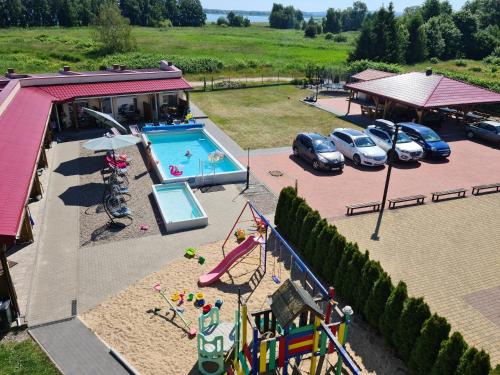 uma vista aérea de um parque infantil com piscina e carros em Pokoje i Domki "Zaciszny" - Mielno em Mielno