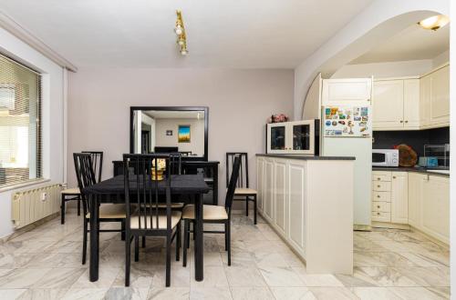 uma cozinha com uma mesa e cadeiras e um frigorífico em Spacious 2-Bedroom Maisonette in City Centre em Plovdiv