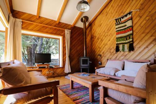 a living room with a couch and a table at Green Baker Lodge in Puerto Bertrand