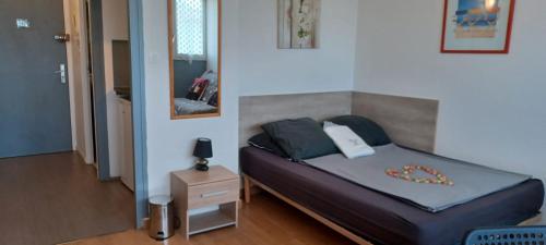 - une chambre avec un grand lit et une tête de lit dans l'établissement Studio proche CHU BORDEAUX, à Bordeaux