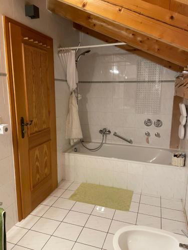 een badkamer met een bad en een wastafel bij Dachgeschosswohnung mit traumhaftem Zugspitzblick bei Garmisch in Farchant