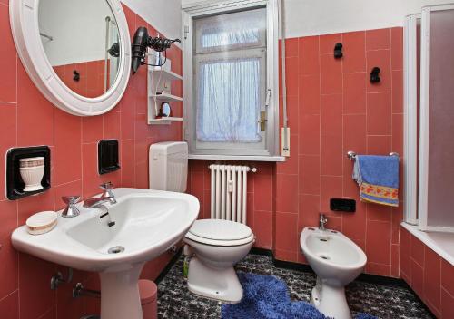 a bathroom with a sink and a toilet and a mirror at Sauze Guesthouse Apartment in Sauze dʼOulx