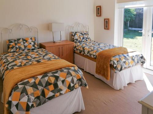 1 dormitorio con 2 camas y ventana en Acres View, en Hoveringham