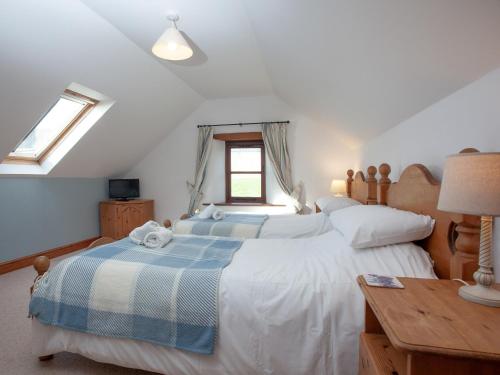 a bedroom with two beds and a window at Smugglers Retreat in Hartland