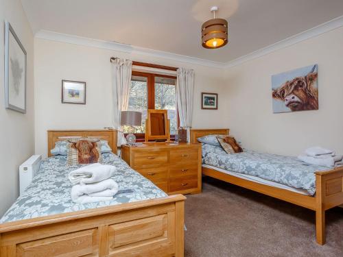 a bedroom with two beds and a tv in it at Ard Taigh in Stron-fearnan