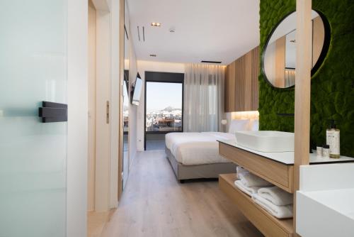 a bathroom with a bed and a sink and a mirror at Incanto Boutique Suites - Neos Kosmos in Athens