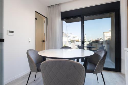a dining room with a table and chairs and a window at Incanto Boutique Suites - Neos Kosmos in Athens