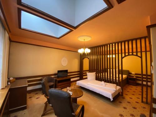 a bedroom with a bed and a desk and a window at Parkhotel Brno in Brno