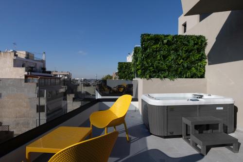 a patio with chairs and a hot tub on a roof at Incanto Boutique Suites - Neos Kosmos in Athens