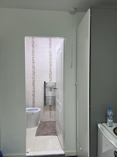 Private room and ensuite Chorlton في مانشستر: حمام أبيض مع دش وحوض استحمام