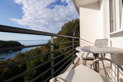 einen Balkon mit einem Tisch und Stühlen sowie Blick auf das Wasser in der Unterkunft Boarding House Lucija in Kostrena