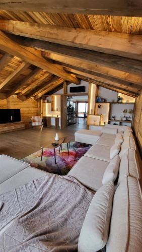 un grand lit dans une chambre avec des plafonds en bois dans l'établissement Chalet Les Cochettes, à Courchevel