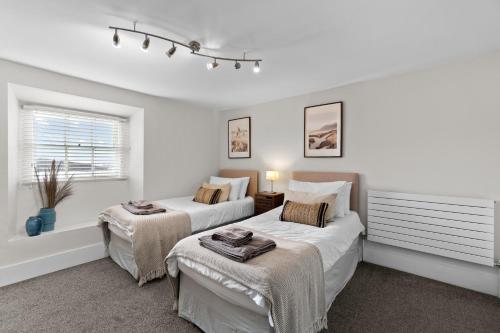 a bedroom with two beds and a window at NEW 2023 Modern Luxury Holiday Home on the Beach in Devon - Free Parking, Pets Welcome, Sleeps 10 in Plymouth