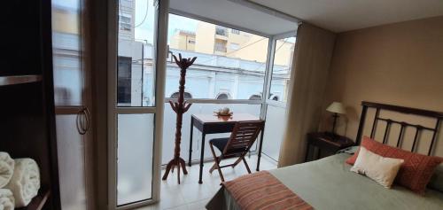 a bedroom with a bed and a table and a desk at Departamento Caseros in Salta
