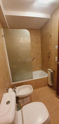 a bathroom with a toilet and a sink and a tub at Departamento Caseros in Salta