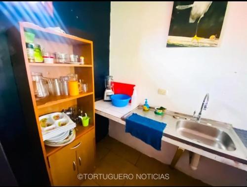 a small kitchen with a sink and a counter at Casa Artavia in Tortuguero