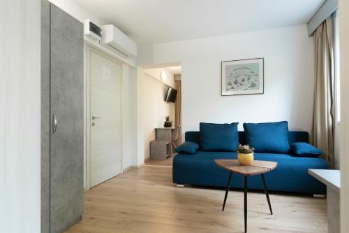 a living room with a blue couch and a table at Boarding House Lucija in Kostrena