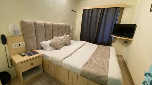 - une petite chambre avec un lit et une télévision dans l'établissement Hotel The Meadows Open Terrace Bonfire, à Manali