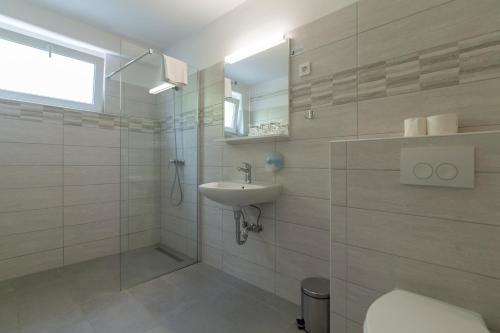 a bathroom with a sink and a toilet and a shower at Boarding House Lucija in Kostrena