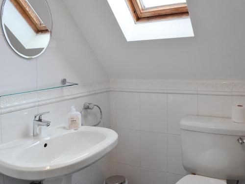 a white bathroom with a sink and a mirror at The Bungalow in Gristhorpe