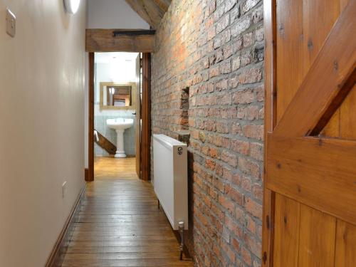 a hallway with a brick wall and a door at The Granary in Hornsea