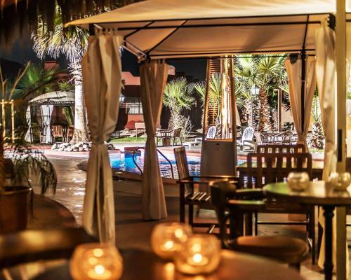 a restaurant with tables and chairs and an umbrella at Hotel Serena Suite in La Serena