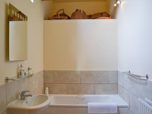 a bathroom with a sink and a bath tub at Binbrook House Mews in binbrook