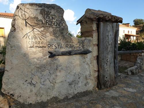a sign on the side of a stone wall at Casa Rural don Rosendo in Olmeda de Cobeta