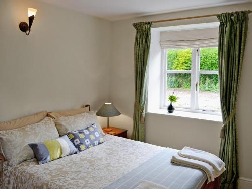 a bedroom with a bed and a window at Coach House in Abbey Dore