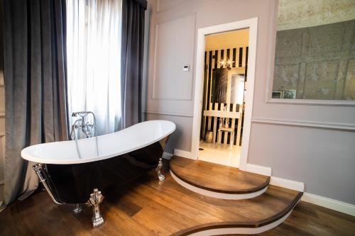 a bath tub sitting on a wooden floor in a bathroom at Relais San Lorenzo In Lucina in Rome