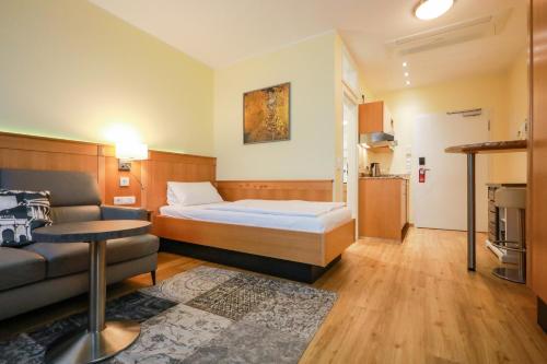 a hotel room with a bed and a couch at Work & Travel - KRAL Hotels Erlangen in Erlangen