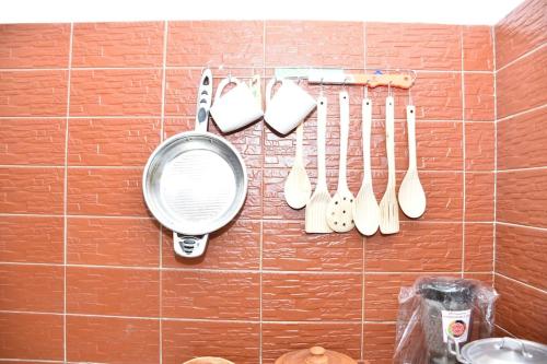 a rack of utensils hanging on a wall at Tranquillité Cotonou in Cotonou