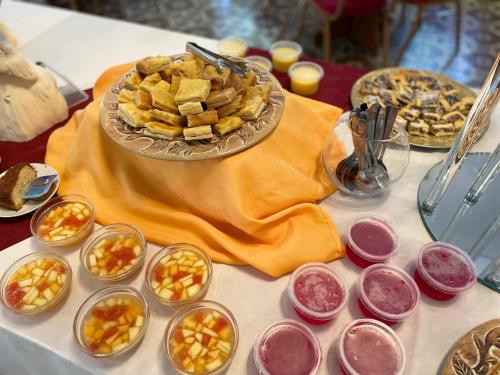 a table with a plate of food and bowls of food at Hotel Select in Piriápolis