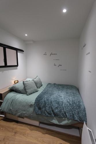 a bedroom with a bed and writing on the wall at Coin détente à Espaly in Espaly-Saint-Marcel