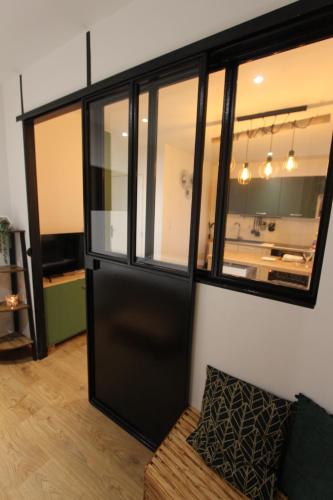 a living room with a black door and a couch at Coin détente à Espaly in Espaly-Saint-Marcel