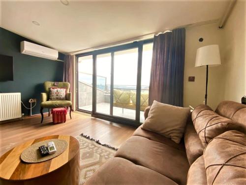 a living room with a couch and a table at Jazzy Homes - Modern & Stylish Flat - Bosphorus View, Terrace in Istanbul