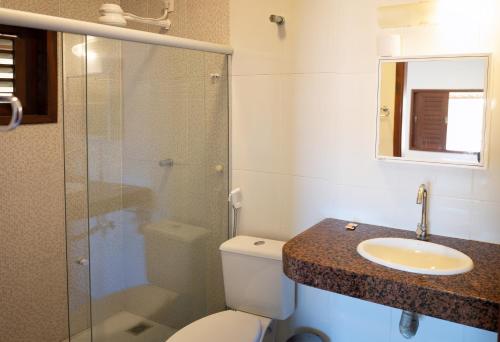 uma casa de banho com um WC, um lavatório e um chuveiro em Zion Suítes em Jericoacoara