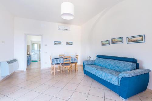 ein Wohnzimmer mit einem blauen Sofa und einem Tisch in der Unterkunft Villa Beatrice in Sorrent