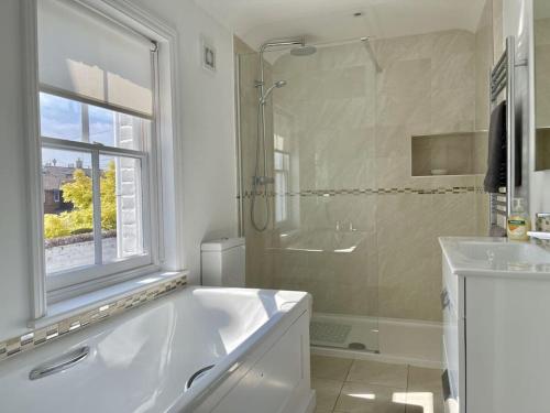 a bathroom with a tub and a shower and a sink at 7 Alfred Square in Deal