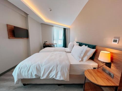 a hotel room with two beds and a television at Yalçındağ Otel Burdur in Burdur