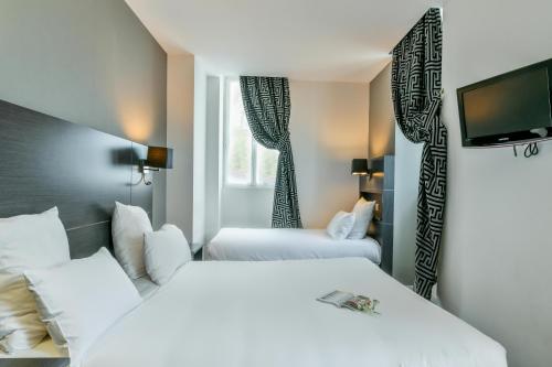 Habitación de hotel con 2 camas y TV de pantalla plana. en Hôtel Logis Laurent Rodriguez, en Cambo-les-Bains