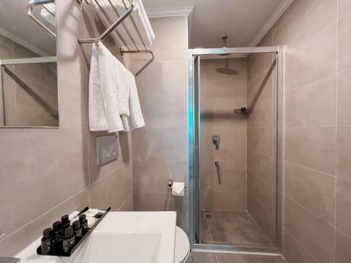 een badkamer met een douche, een toilet en een wastafel bij Yalçındağ Otel Burdur in Burdur